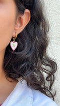 gold hoop earring with a pink heart-shaped charm.